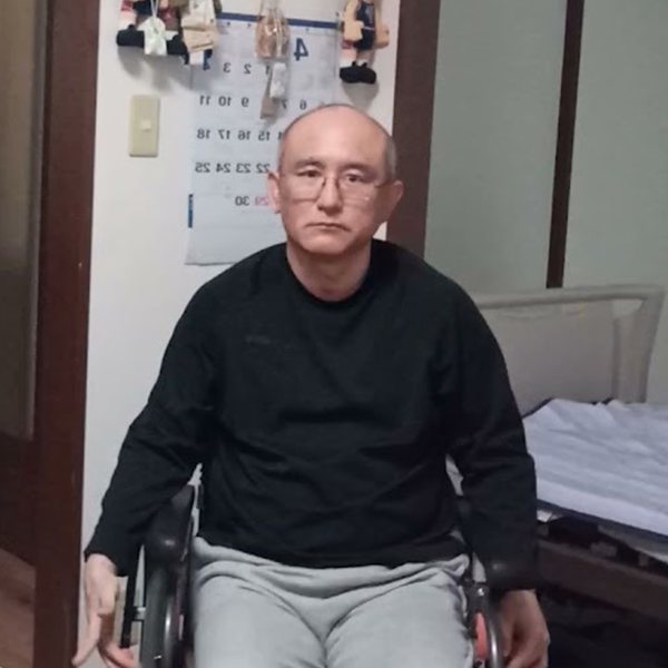 自宅で車椅子に座る、書いている人